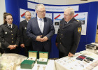 Innenminister Joachim Herrmann im Gespräch mit Polizeibeamten, davor liegen beschlagnahmte Gegenstände der Grenzpolizei auf Tischen.