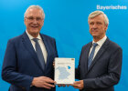 Innenminister Joachim Herrmann und Dr. Thomas Gößl, Präsident des Landesamts für Statistik halten zusammen Statistisches Jahrbuch