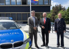 Ministerpräsident Dr. Markus Söder, Innenminister Joachim Herrmann und Polizeibeamter neben Polizeiauto vor Gebäude