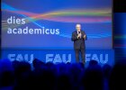 Auf dem Bild ist Innenminister Joachim Herrmann bei seiner Rede auf dem "Dies academicus" der FAU Erlangen zu sehen. Innenminister Joachim Herrmann steht auf einer Bühne, dem Publikum zugewandt.