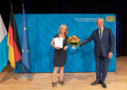 Geehrte mit Kommunaler Dankurkunde und Innenminister Herrmann mit Blumenstrauß
